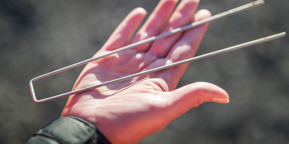 Hand holding a ground staple