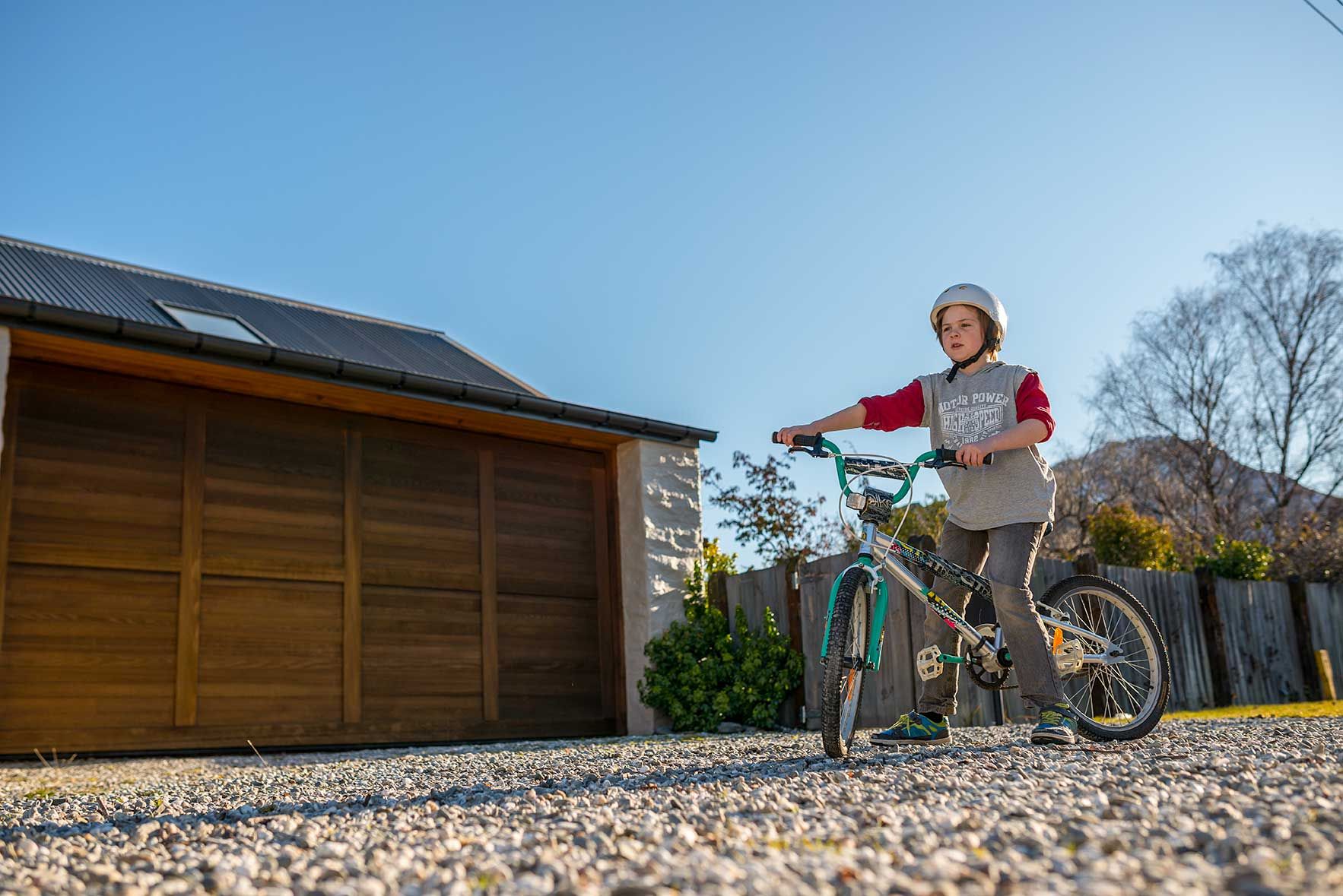 Boy riding his bike on a firm permeable paved driveway