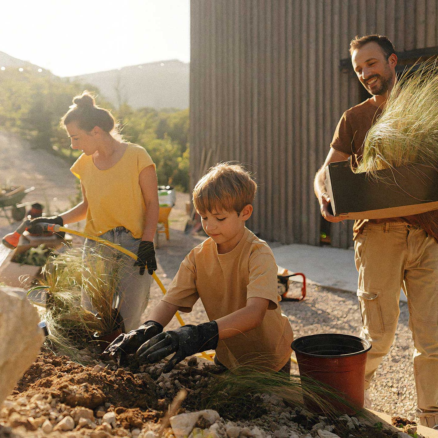 Family planting grasses together in a new home garden