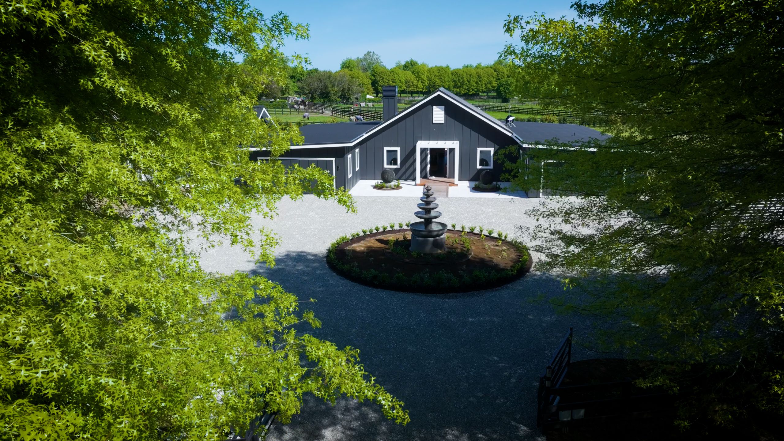 Aerial view of a gravel driveway turning circle with a central fountain